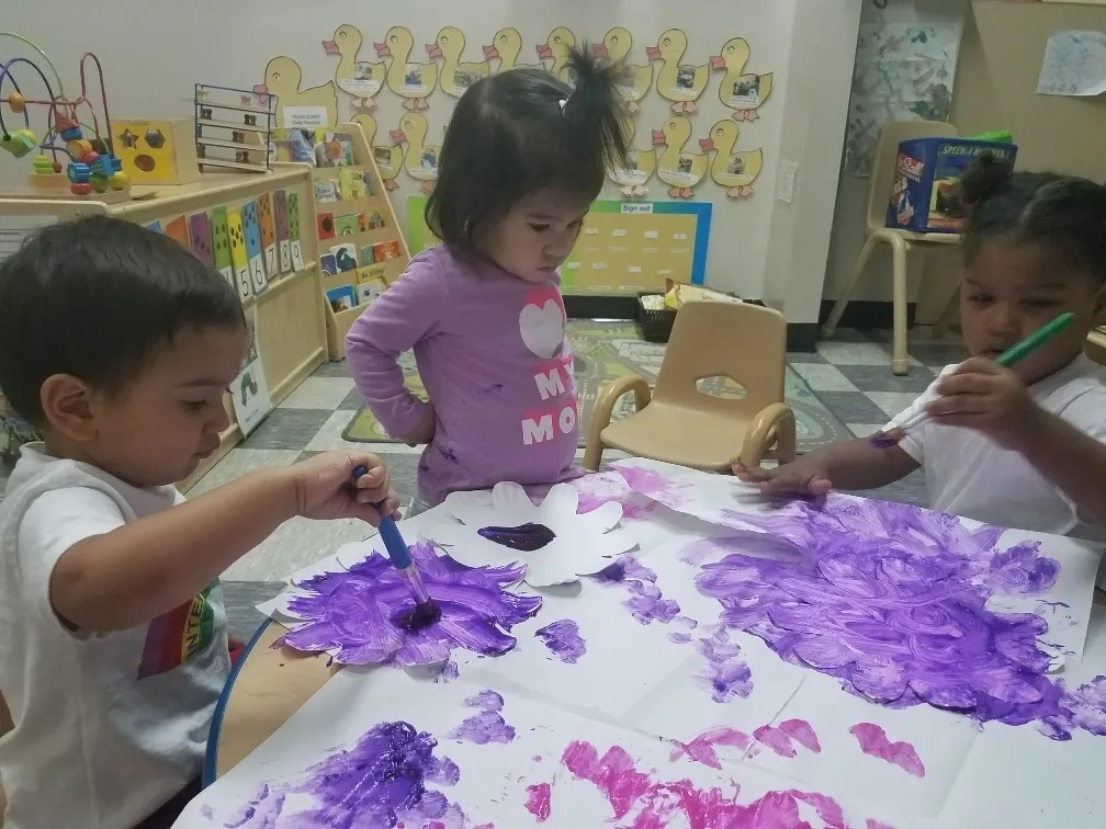 Children painting with purple paint