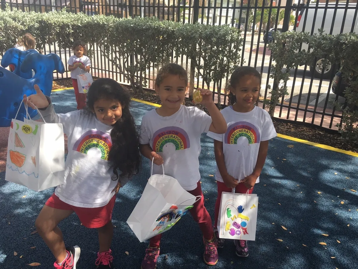 Children holding decorated gift bags outdoors