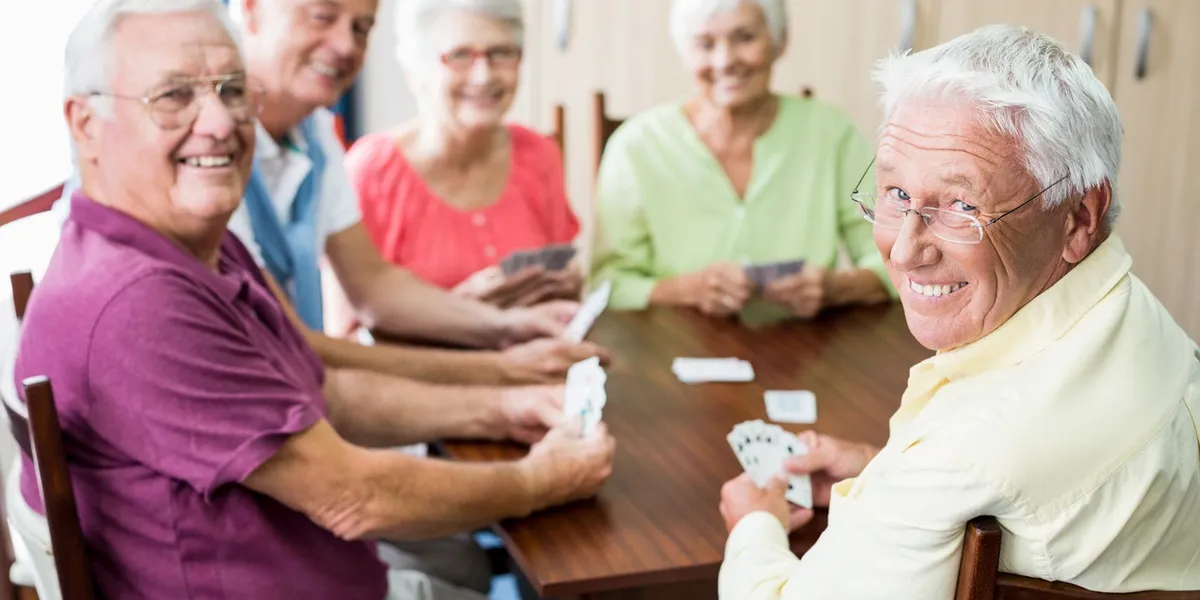 Elderly friends playing cards happily