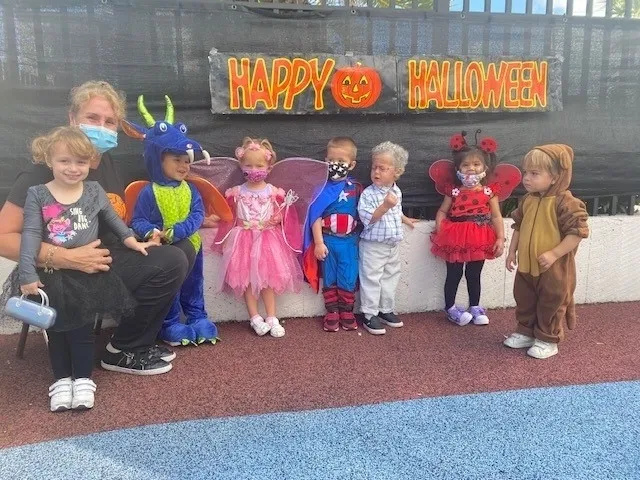 Kids in costumes under Happy Halloween sign