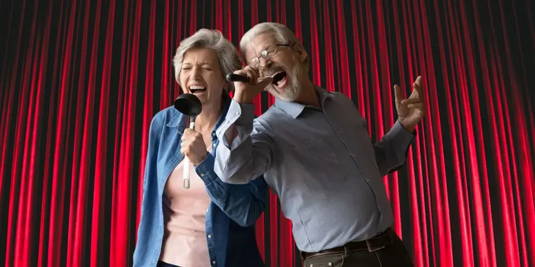 Elderly couple singing passionately on stage